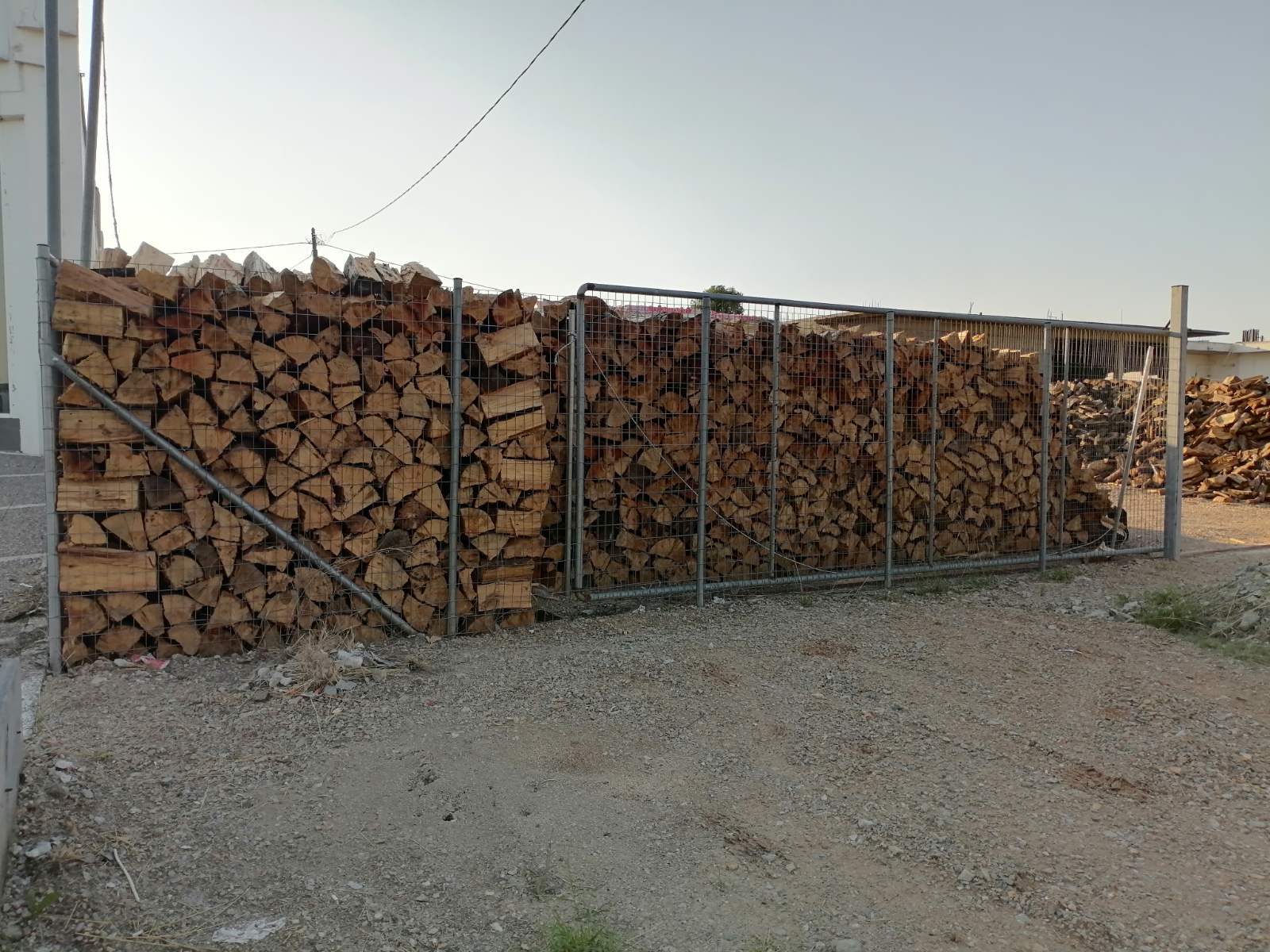 Στοιβαγμένα καυσόξυλα σε μεταλλική περίφραξη